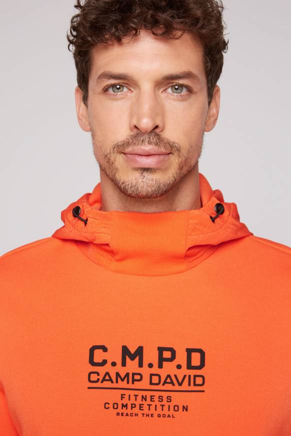 Soccx Hoodie im Materialmix mit Artwork und Rückentasche signal orange Begrenzte Freigabe